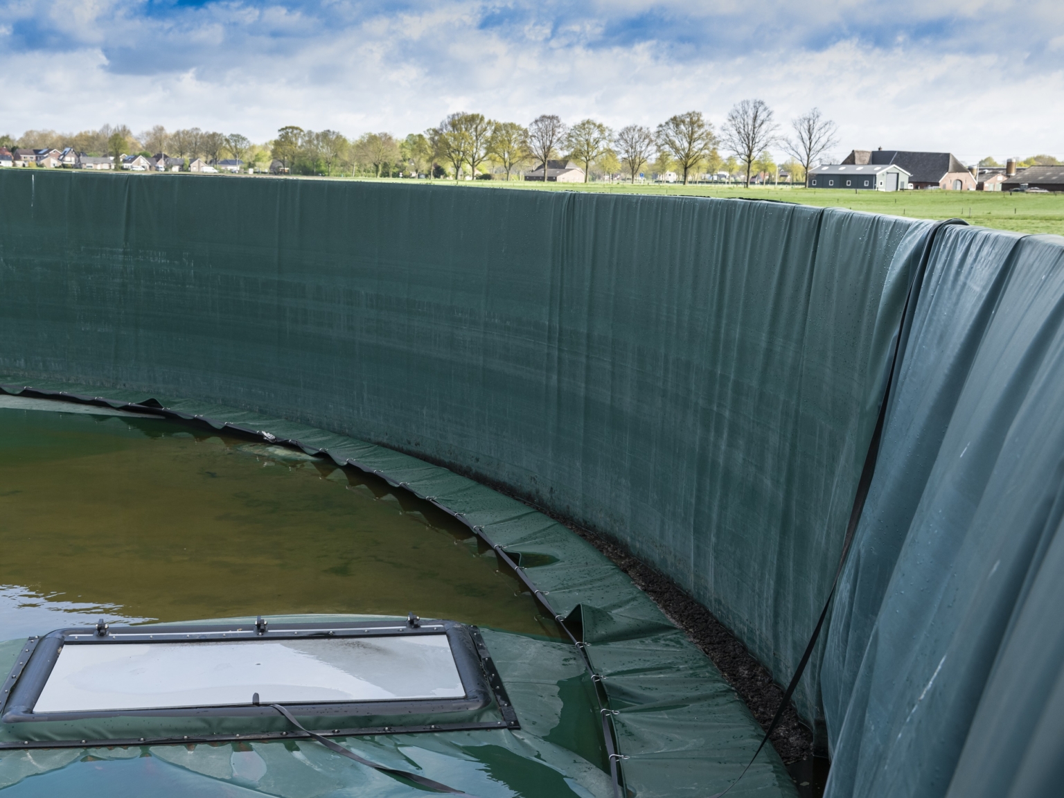 Floating cover with mixing hatch in a slurry silo