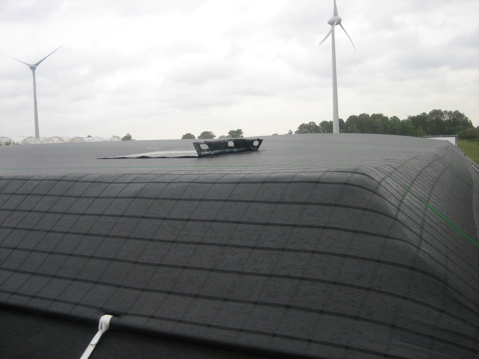 Hatch of a tensioned cover on a water reservoir