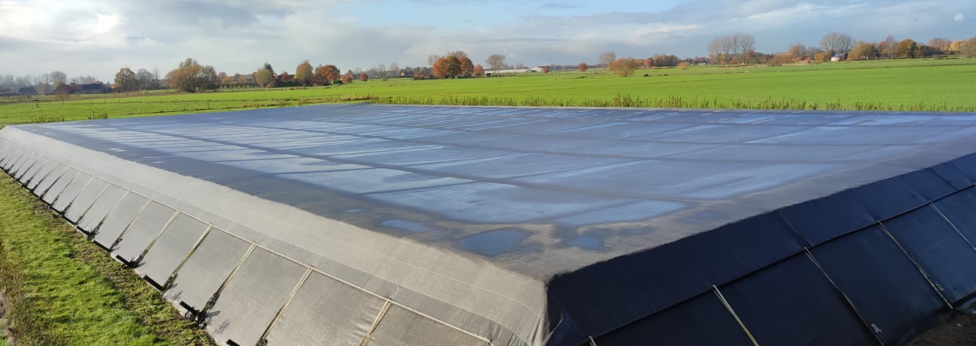 Tensioned cover mounted on a water basin anchored at the toe of the dike