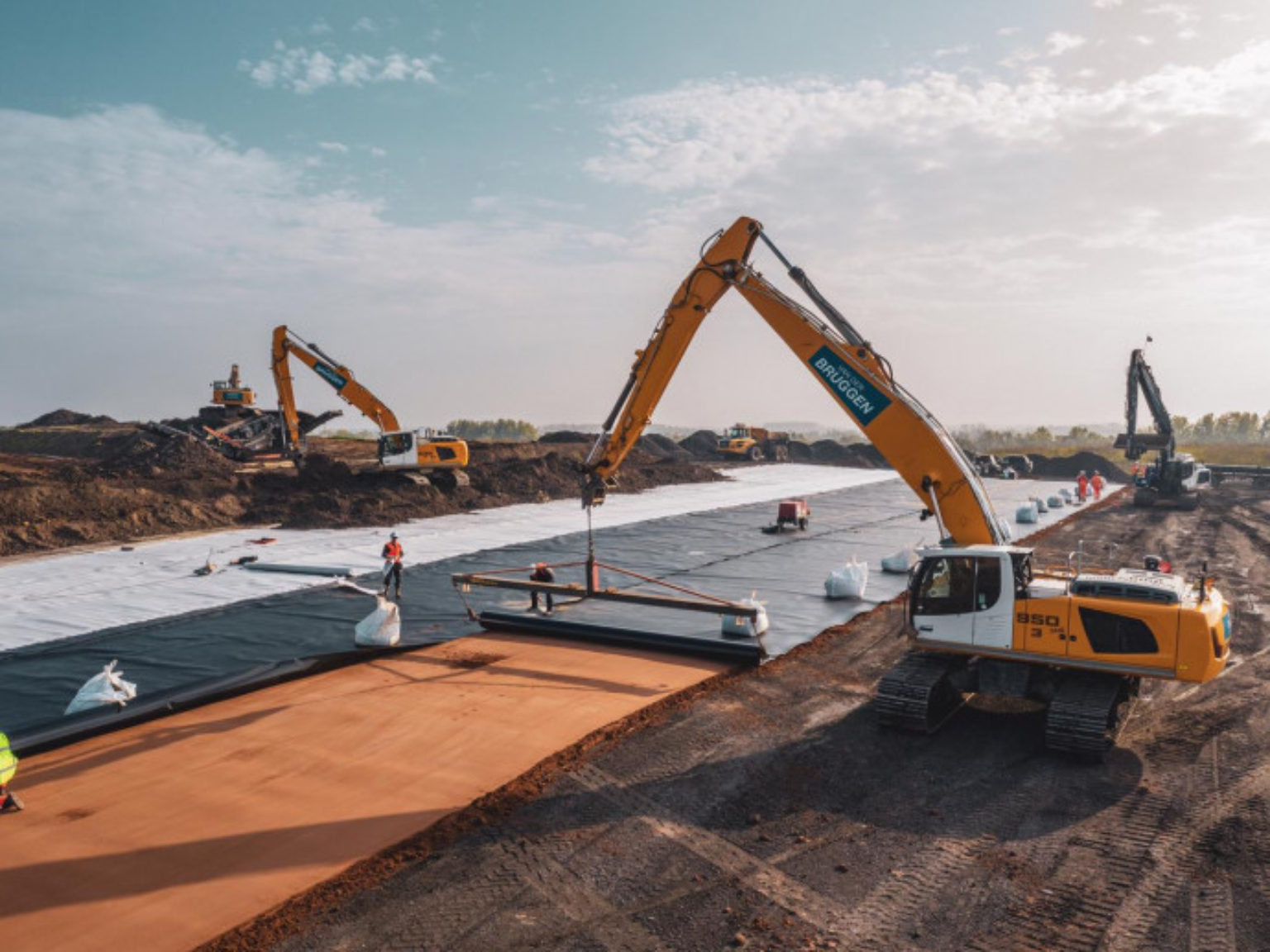 Excavators laying down membranes on waste disposal site